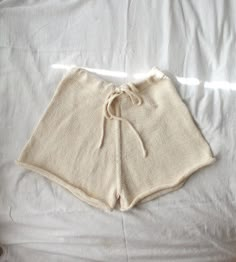 a pair of white shorts laying on top of a bed