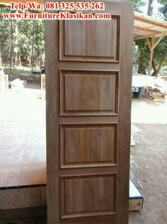 an open wooden door sitting in the middle of a floor covered with wood planks