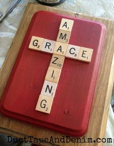 a cross made out of scrabble tiles sitting on top of a table