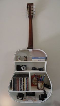 a guitar shaped shelf with books and other items