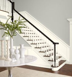 there is a vase with flowers on the table in front of the stair railings