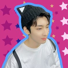 a young man wearing a black hat with stars around it on a pink and blue background