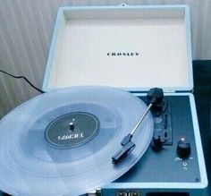 an old record player sitting on top of a table next to a box with the word crosley written on it