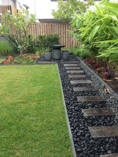 a small garden with stepping stones in the grass