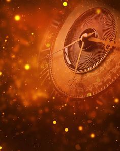 a close up of an analog clock on a dark background with gold dust and stars