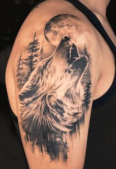 a man with a wolf tattoo on his arm and shoulder is looking at the moon