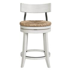 a white stool with a wicker seat and back rests against a white background,