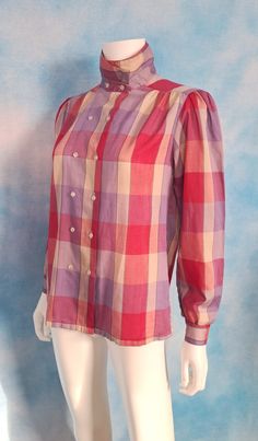 A country chic madras plaid thin cotton blend blouse in purples, pinks and reds. Double breasted button up can button into a high collar or lay flat attractively. Slight bishop sleeves and gathers at the fronts of the shoulders. Excellent condition. Decade: 1980s Label: Honors Material: cotton blend Vintage Condition: excellent (From a pet and smoke free home) Measurements are taken flat and doubled where necessary. This blouse will fit a size medium best. Neck: 14" Shoulder span: 14" Sleeve len Antique Outfits, Horror Clothing, Vintage Fashion 1980s, Horror Clothes, Madras Plaid, Vintage Horror, Bishop Sleeve, Country Chic, Historical Clothing