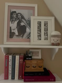 a shelf filled with books and pictures on top of it