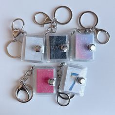 six different keychains are arranged on top of each other