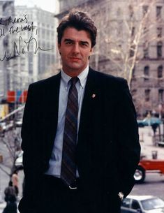 a man wearing a suit and tie standing in the street