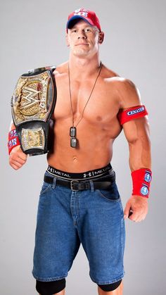 a shirtless man holding a wrestling belt in his right hand and looking at the camera