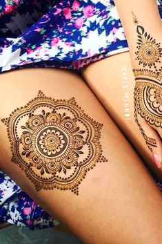 two legs with henna tattoos on them, one is showing off the intricate design