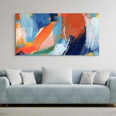 an abstract painting hangs on the wall above a couch