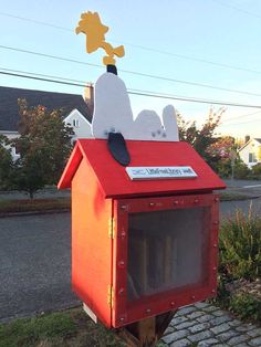 a red mailbox with a yellow dog on top