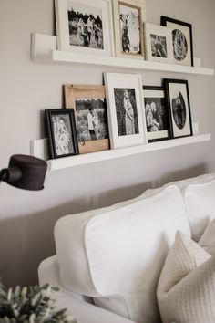 a white couch with pictures on the wall above it