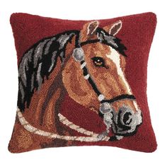 a brown horse hooked up to a red pillow on a white background with the head of a horse embroidered onto it