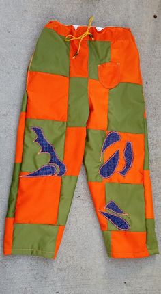 an orange and green patchwork pants laying on the ground