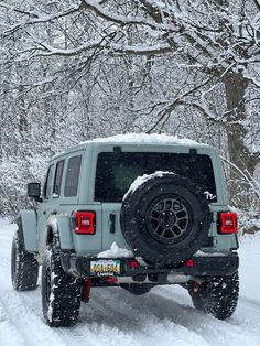 the jeep is driving down the snowy road