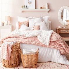 a bedroom with pink walls and white bedding, wicker baskets on the floor