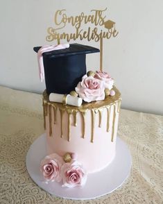 a graduation cake decorated with pink roses and gold icing