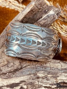 Size: 7 3/8" Gap: 1 1/2" Width: 1 1/4" Weight: 48 grams Hallmark: Sterling This stunning Old Pawn Navajo Sterling Silver Cuff Bracelet features a Turquoise stone measuring 3/4" wide encircled with 2 twisted wire ropes. The stone is a beautiful green with a gorgeous dark brown matrix. The cuff also features traditional Southwest Indian symbols and 13 hand stamped arrowheads on each side of the cuff, 26 total. This cuff just screams the Old Southwest and you will enjoy having in your collection. L Luxury Southwestern Style Jewelry Gift, Luxury Southwestern Style Bangle Jewelry, Luxury Southwestern Engraved Jewelry, Luxury Artisan Cuff Bracelet With Concho, Luxury Southwestern Gemstone Cuff Bracelet, Luxury Handmade Southwestern Bangle, Luxury Southwestern Collectible Jewelry, Luxury Southwestern Cuff Bracelet Gift, Luxury Handmade Southwestern Style Bangle