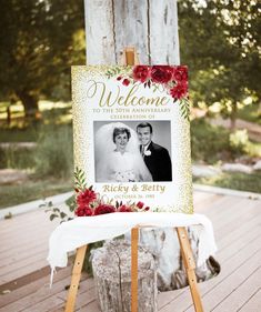 an easel with a wedding photo on it and flowers around the frame is sitting on a wooden deck