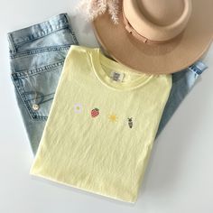 Welcome the sunny days with our Sunkissed Strawberry and Bee Embroidered T-Shirt! Made from 100% cotton Soft Comfort Colors, this shirt is both stylish and comfortable, perfect for your summer adventures.Features:Material: 100% cotton Soft Comfort ColorsSizes: S, M, L, XL, 2XL (refer to size chart in images)Colors Available: Banana, Bay, Blossom, Chalky Mint, Chambray, Ivory, Orchid, Peachy, Violet (Note: Colors may vary slightly due to monitor settings)Design: Summer-inspired embroidery featuring a daisy, strawberry, sun, and bee on the center chestCare Instructions: Machine wash cold, tumble dry lowThis Sunlissed Strawberry and Bee Embroidered T-Shirt is a delightful addition to your wardrobe, bringing a touch of sunshine wherever you go. Perfect for picnics, beach days, or casual outing Casual Summer T-shirt With Embroidered Graphics, Trendy Embroidered Summer T-shirt, Cute Embroidered Summer Tops, Yellow Organic Cotton Crew Neck Top, Cute Spring Tops In Organic Cotton, Casual Yellow Embroidered T-shirt, Casual Yellow T-shirt With Embroidered Graphics, Casual Yellow Tops With Embroidered Graphics, Trendy Embroidered T-shirt For Summer