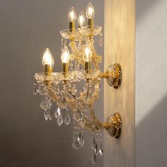 a crystal chandelier hanging from the side of a wall in a room with white walls