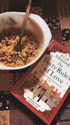 there is a bowl of cereal and a book on the table next to it that says eat what the forty rules of love