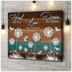 a wooden sign with dandelions on it that says heal the past, live the future