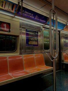 an empty subway car with orange seats