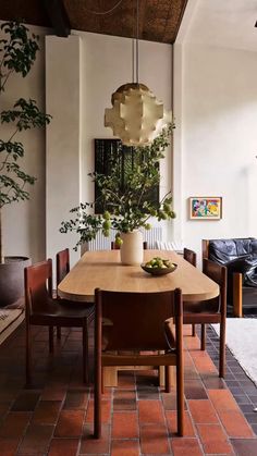 a dining room table with chairs and a potted plant