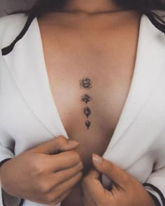 a woman is showing off her chest with three flowers on the left side and four petals on the right side