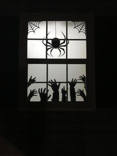 silhouettes of hands reaching for a spider through a window