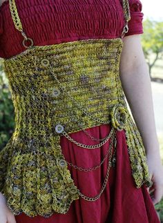 a woman in a red dress with chains on her waist and an unusual belt around her waist