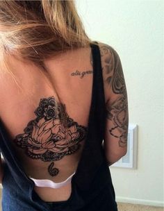 the back of a woman's body with tattoos on it