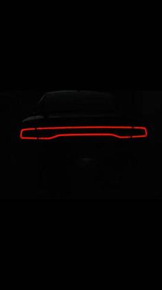 the tail light of a car in the dark with its lights turned on and it is glowing red