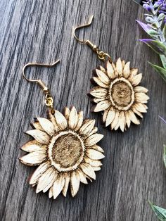 These beautiful laser cut & etched sunflower earrings are made from 1/8" Maple hardwood. They’re light as a feather and ideal for daily wear! Choose either gold tone or silver tone hardware. Ear wires are stainless steel. Wood part of earring measures approximately 1.6” round at the widest parts. Laser cut, crafted by hand and shipped from the United States. Wood grain varies with every piece and computer monitor settings can vary which may result in displaying slight color differences. You shou Laser Cut Wood Earrings, Engraved Earrings, Sunflower Earrings, Light As A Feather, Earring Hook, Steel Wood, Earring Ideas, Maple Hardwood, Nature Inspired Jewelry