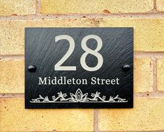 a black sign on a brick wall that says 28 middleleton street in white lettering