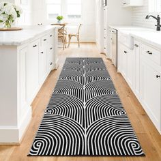 a black and white rug in the middle of a kitchen