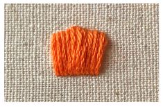 an orange thread on a white cloth