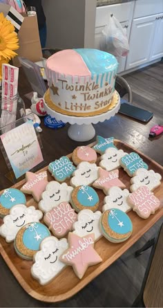 decorated cookies on a wooden tray next to a cake and greetings for someone's special occasion