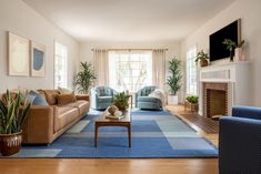 a living room with couches, chairs and a fire place in the middle of it