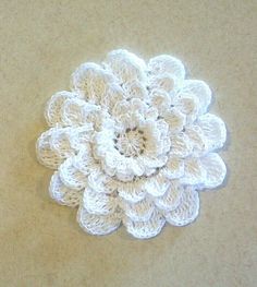 a white crocheted flower on a beige surface