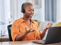 a woman sitting at a desk with a laptop and headphones on