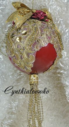 a red ornament hanging on a white furnishing with gold trimmings