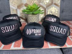 four black hats sitting on top of a table next to a potted succulent