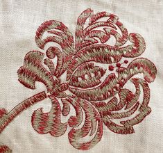 an embroidered piece of cloth with red and white designs