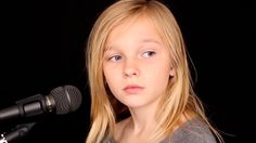 a young blonde woman standing in front of a microphone